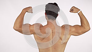 Rearview shot of a muscular shirtless man flexing his back and arms muscles