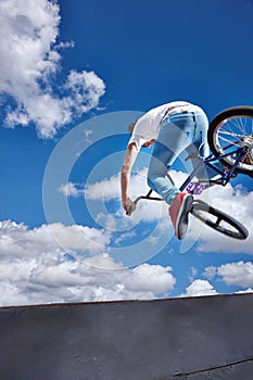 Practicing for the x games. Rearview shot of a teenage boy riding a BMX at a skatepark. photo