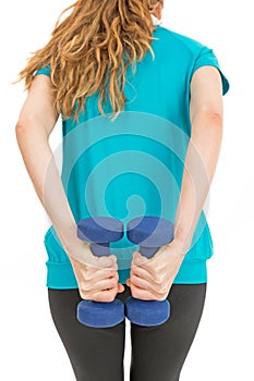 Rearview of woman doing strength training with dumbbells
