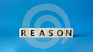 Reason symbol. Concept word Reason on wooden cubes. Beautiful blue background. Business and Reason concept. Copy space