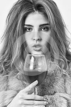 Reasons to drink red wine in wintertime. Girl fashion makeup wear fur coat hold wine glass. Woman drink wine. Lady