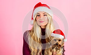 Reasons to love christmas with pets. Girl attractive blonde hold dog pet pink background. Woman with puppy wear santa