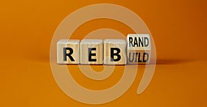 Rebrand and rebuild symbol. Turned a wooden cube and changed the word rebrand to rebuild. Beautiful orange table, orange