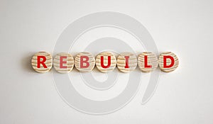 Rebuild and build symbol. The concept word Rebuild on wooden circles. Beautiful white background, copy space. Business rebuild and