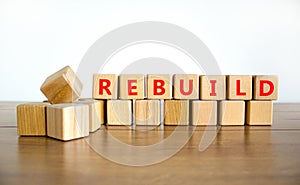 Rebuild and build symbol. The concept word Rebuild on wooden cubes. Beautiful wooden table, white background, copy space. Business