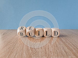 Rebuild symbol. Concept word rebuild on wooden cubes on a beautiful wooden table.
