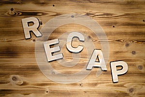 RECAP word made of wooden block letters on wooden board. photo