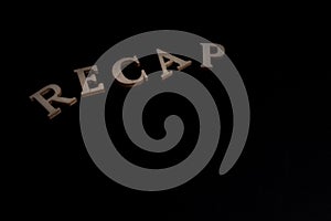RECAP word made of wooden  letters isolated on black background