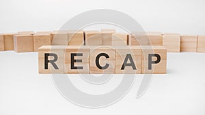 Recap word, text, written on wooden cubes, building blocks, over white background