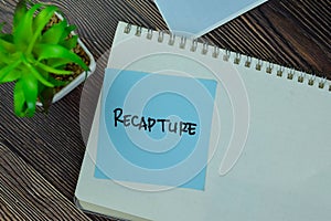 Recapture write on sticky notes isolated on Wooden Table