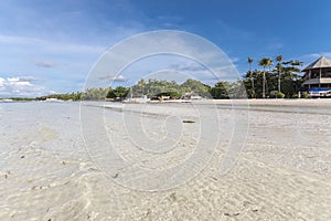 Receding tide exposing the pristine white fine sand in Doljo Beach, Panglao, Bohol. Crystal clear waters and a perfect clear day