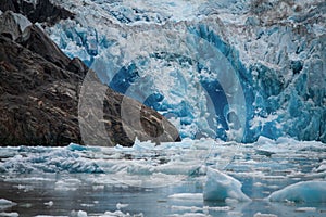 Recently calved ice flows or icebergs in the cold water in front of the glacier in Tracy Arm Fjord, Alaska.