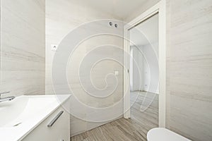 recently renovated bathroom with imitation marble tiles, wooden