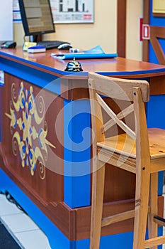 Reception check in desk with bell, computer and chair at hotel check in desk, selective focus