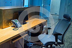 Reception desk, chair and telephone in modern business building