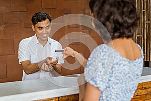 The receptionist accepts credit card payments from female guests photo
