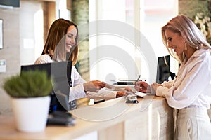 Receptionist and businesswoman at hotel front desk