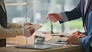 Receptionist hands giving keys at hotel counter closeup. Tourist couple check in