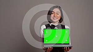 Receptionist showing greenscreen display on personal laptop,