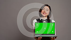 Receptionist showing greenscreen display on personal laptop,