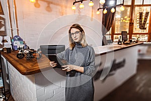 Receptionist standing at reception counter in office