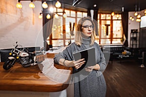 Receptionist standing at reception counter in office