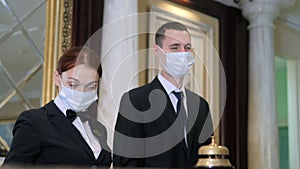 Receptionists wearing medical mask in hotel. Protection employees on workplace