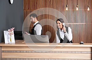 Receptionists working at desk in lobby