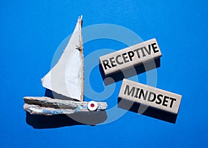 Receptive Mindset symbol. Concept word Receptive Mindset on wooden blocks. Beautiful blue background with boat. Business and