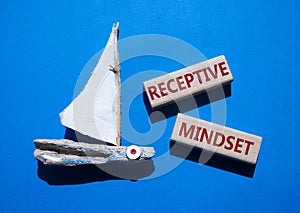 Receptive Mindset symbol. Concept word Receptive Mindset on wooden blocks. Beautiful blue background with boat. Business and