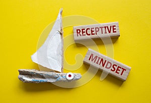 Receptive Mindset symbol. Concept word Receptive Mindset on wooden blocks. Beautiful yellow background with boat. Business and