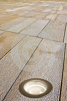 Recessed floor lamp on a modern stone pavement