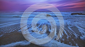 Recessing tide and moonrise over sandy ocean beach photo