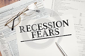 Recession fears symbol. Words on white paper with tax forms