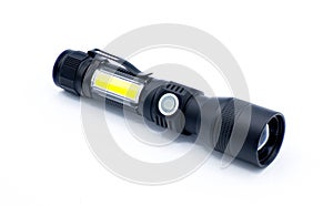 rechargeable battery powered flashlight isolated on white background. black hard plastic with soft rubber on off button. yellow