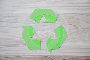 Reciclable symbol on a wooden background photo