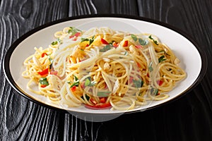 Recipe for classic aglio e olio pasta with fried garlic, parsley and hot pepper close-up in a plate. horizontal