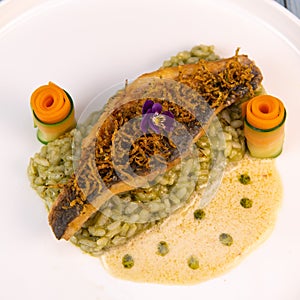 Recipe for fried fillet of sea bass with herb risotto, white wine sauce, fresch creme, roll of carrot and courgette