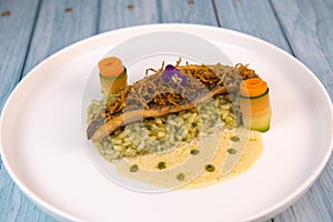 Recipe for fried fillet of sea bass with herb risotto, white wine sauce, fresch creme, roll of carrot and courgette
