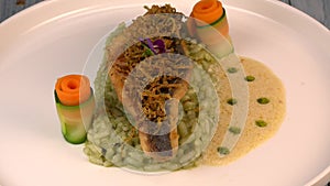Recipe for fried fillet of sea bass with herb risotto, white wine sauce, fresh creme, roll of carrot and courgette