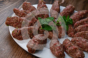 RECIPE FOR LEBANESE KEBBE NAYYHE, RAW MINCED BEEF, MARJORAM, MINT, ONIONS, CRUSHED WHEAT, SEVEN SPICES, CINNAMON