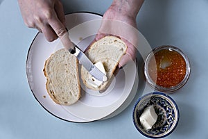 Recipe for making a sandwich with red caviar. Step by step, the girl spreads butter on the bread