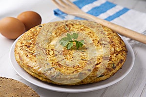 Spanish potato omelette with zucchini and young garlic. Traditional tapa recipe with egg, potato and onion. photo