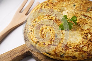 Spanish potato omelette with zucchini and young garlic. Traditional tapa recipe with egg, potato and onion. photo