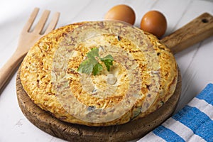 Spanish potato omelette with zucchini and young garlic. Traditional tapa recipe with egg, potato and onion. photo