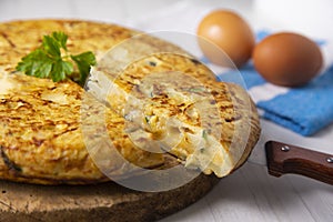 Spanish potato omelette with zucchini and young garlic. Traditional tapa recipe with egg, potato and onion. photo