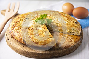 Spanish potato omelette with zucchini and young garlic. Traditional tapa recipe with egg, potato and onion. photo