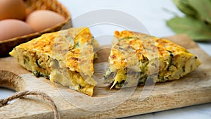 Spanish potato omelette with zucchini and young garlic. Traditional tapa recipe with egg, potato and onion. photo