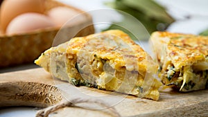 Spanish potato omelette with zucchini and young garlic. Traditional tapa recipe with egg, potato and onion. photo