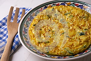 Spanish potato omelette with zucchini and young garlic. Traditional tapa recipe with egg, potato and onion. photo